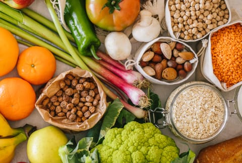 Fresh Fruits And Vegetables In Reusable Bags On Kitchen Table