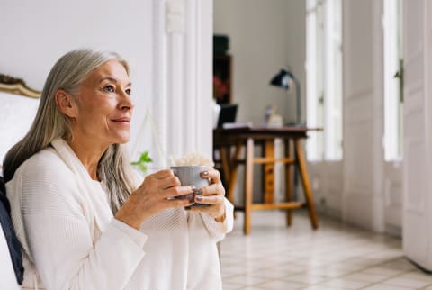 older woman sitting with coffee cup older woman sitting with coffee cup