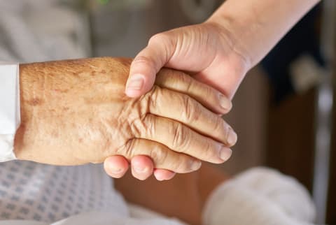 Health practitioner holding the hand of an elderly patient Health practitioner holding the hand of an elderly patient