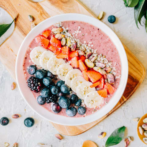 Acai smoothie bowl with blueberries, blackberries, strawberries, banana, hemp seeds and pistachio