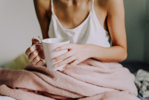 Young Woman Drinking Tea In Bed